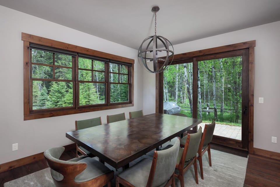 Host long dinners beside sunny windows framing lush greenery.