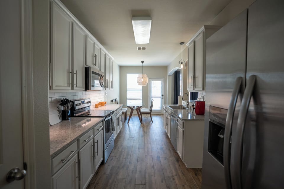Bright modern kitchen with stainless appliances and sunny dining nook