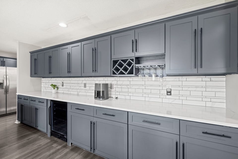 A dedicated coffee and wine station with glass racks and a built-in wine fridge — happy hour made easy.