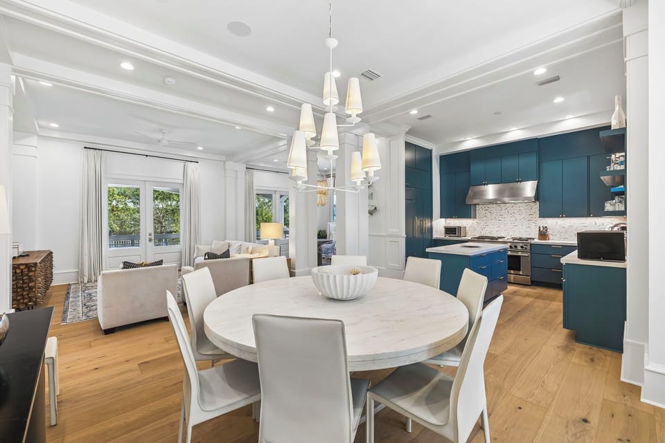 Gather around the elegant dining table in this bright, open-plan space where sophisticated design meets everyday comfort. Natural light spills through tall windows while your modern kitchen awaits your culinary adventures.