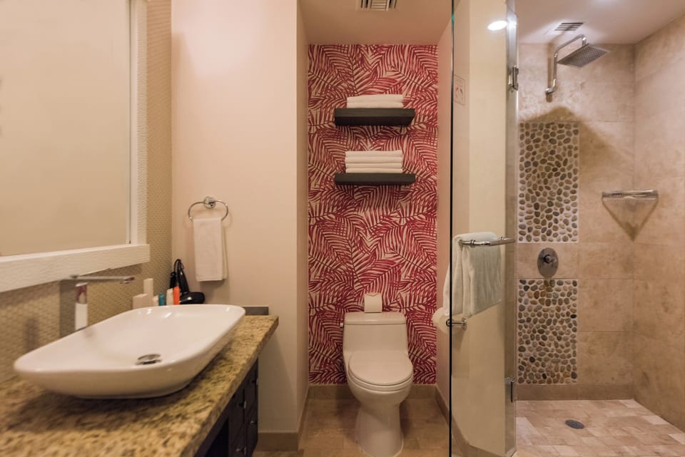 Rinse off in a bright walk-in shower with stone accents.