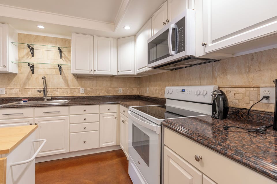 Bright full kitchen with ample counters, full-size appliances, and warm finishes