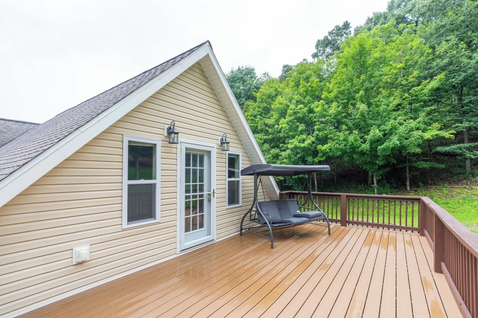 Spacious private deck with covered swing and peaceful wooded views