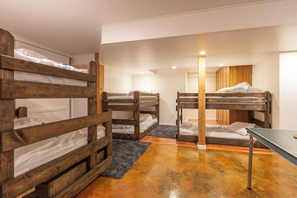 Spacious rustic bunk room with multiple beds and ping pong fun