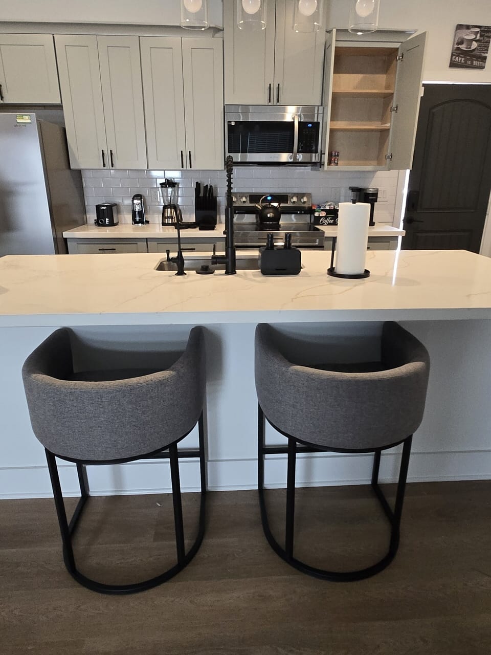 Modern kitchen with waterfall island, bar seating, and sleek finishes