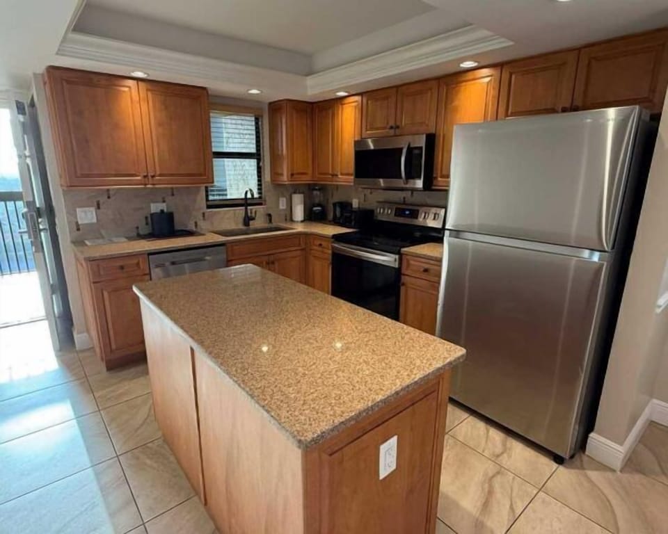 Bright full kitchen with stainless appliances and spacious island