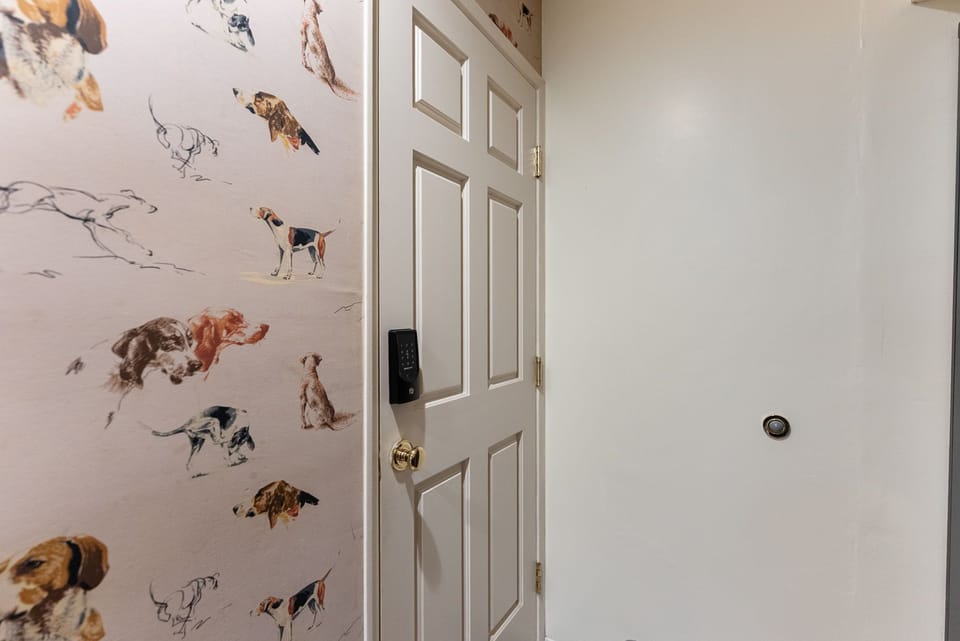 Welcoming entry with smart lock and charming dog-print accent wall
