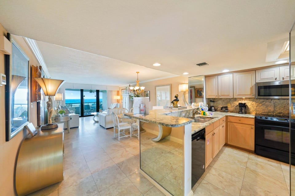 This Gulf front vacation rental features a spacious kitchen with granite countertops and an open layout overlooking the emerald waters.