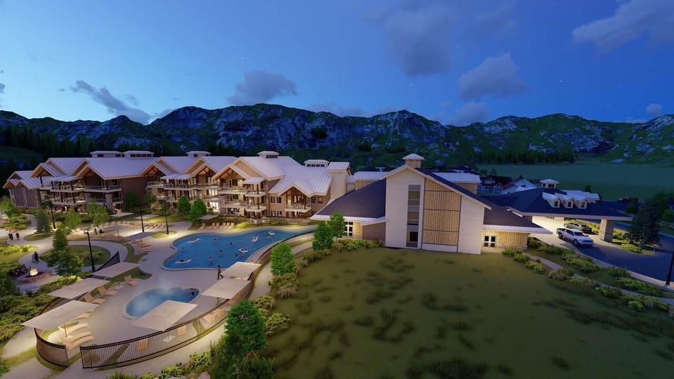 Twilight mountain resort with pool, hot tub, and stunning alpine views
