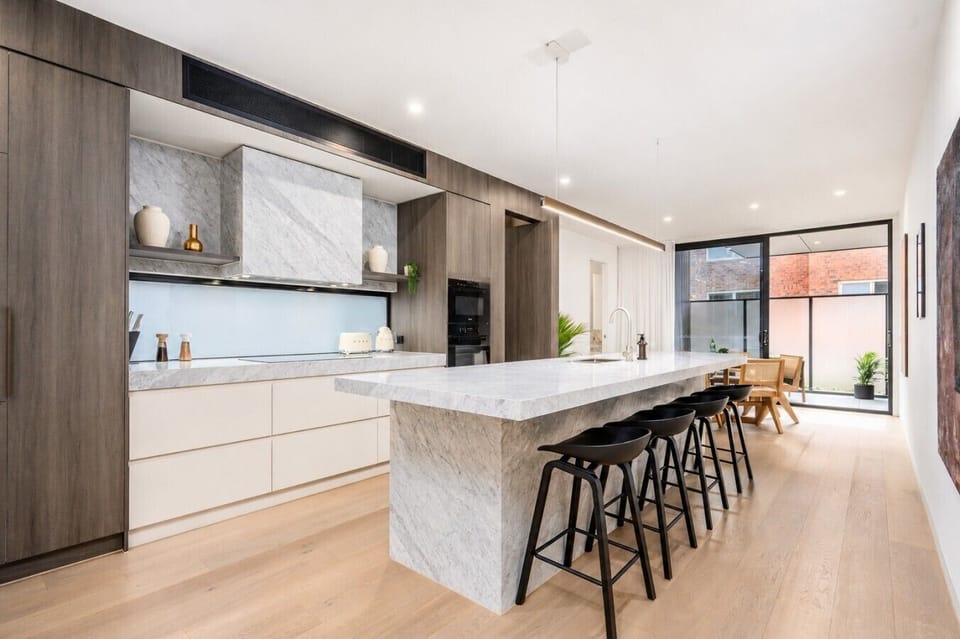 The showpiece kitchen pairs dramatic marble with rich timber joinery