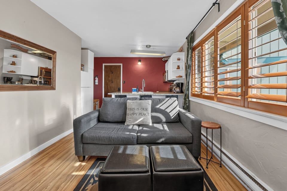 Settle into your cozy living space where natural light streams through plantation shutters, brightening the open layout. Sink into the sofa with a good book or gather around the compact kitchen, ready for your getaway.