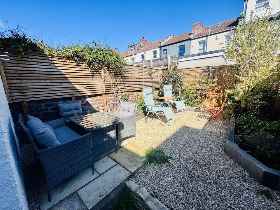 The private garden features outdoor furniture and a dining table for al fresco meals