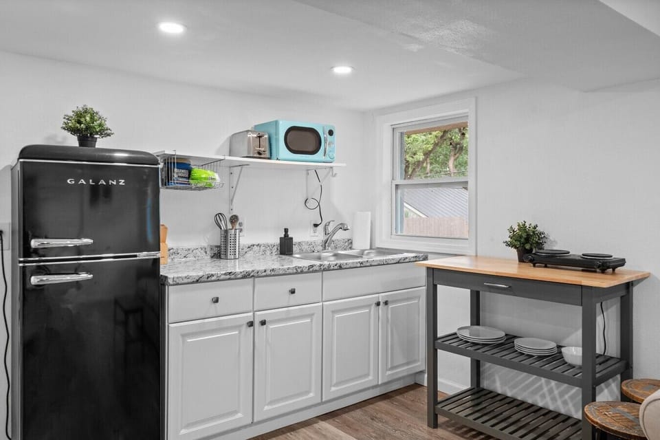 Brew coffee or cook a meal in the retro kitchenette with full-size fridge, granite counters, and cooktop.