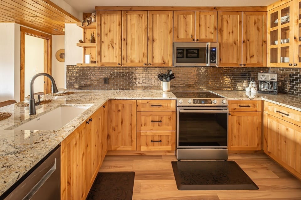 Your fully equipped kitchen features warm wood cabinetry, granite countertops, and modern stainless appliances—everything you need to prepare delicious meals during your stay.