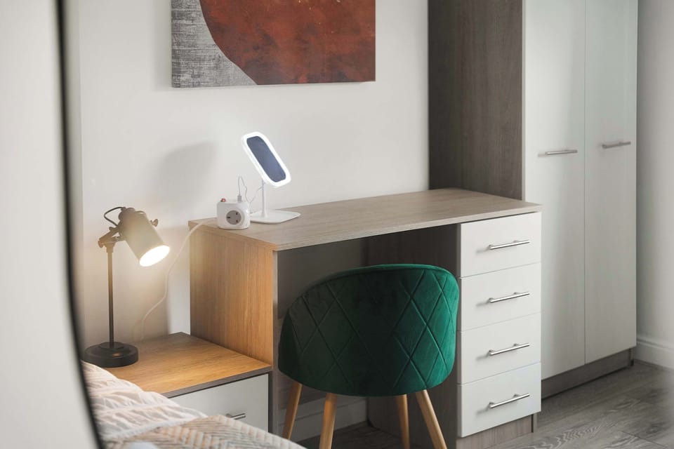 A cosy bedroom with a double bed and an additional single bed, ideal for families or small groups. The room provides wardrobe storage, a desk, bedside furniture, a mirror, a hairdryer and extra hangers.