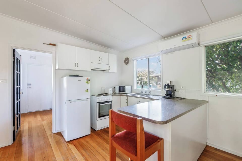 A fully equipped kitchen with an oven, stove, microwave, dishwasher, fridge, Nespresso machine and ample bench space supports effortless home cooking.
