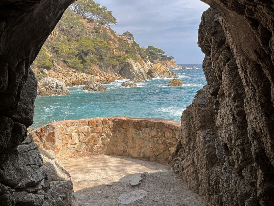 Sea view framed by a rocky coastal cove along the Costa Brava.