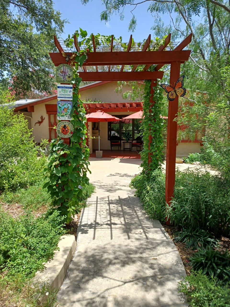 Exterior front yard and front porch with arbor over sidewalk. 