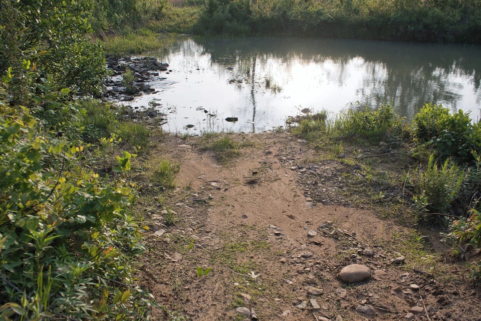 This is the natural river entry area where guests can access the water and load kayaks from the property’s private trail.