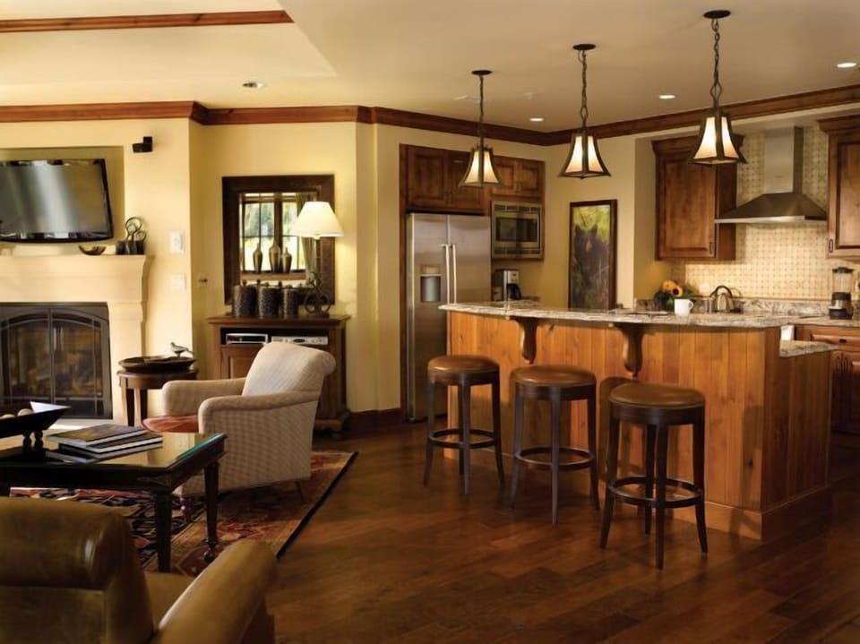 Warm open-concept kitchen and lounge with fireplace and bar seating