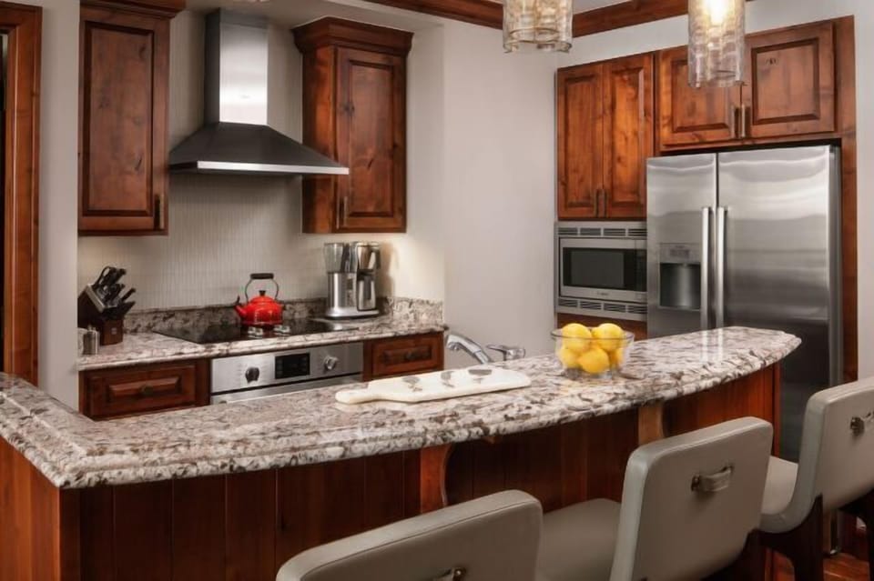 Granite breakfast bar and upscale kitchen with warm wood finishes