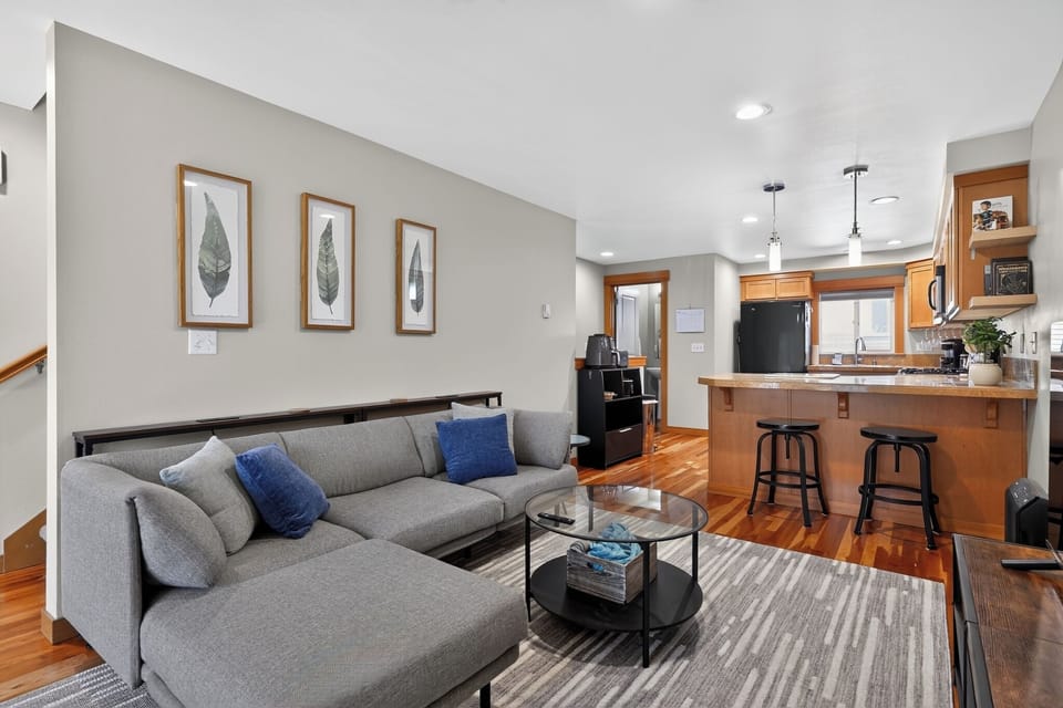 Bright open living space with cozy sectional and breakfast bar seating