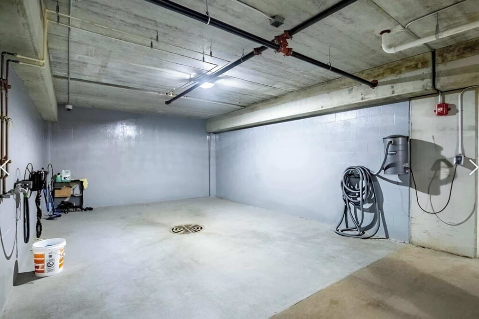 Indoor car-wash bay in the heated garage with hose and drain for year-round vehicle cleaning.