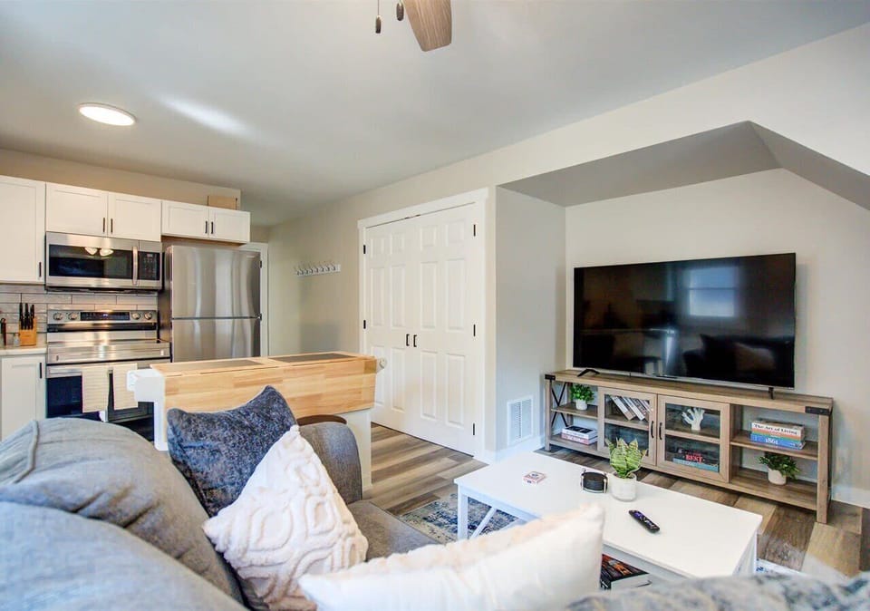 Relax in the cozy living room with a large 65" Roku TV, stylish media console, and plush seating—perfect for streaming your favorite shows or enjoying a quiet night in.