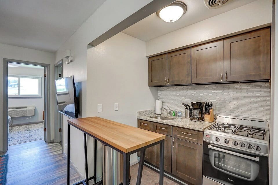 Kitchen fully stocked with cooking and dining utensils. 