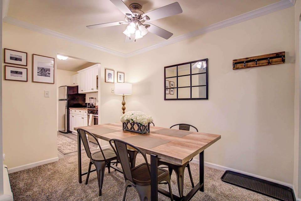 Stylish dining space featuring a wooden table, modern metal chairs, and warm lighting—perfect for enjoying meals or entertaining.