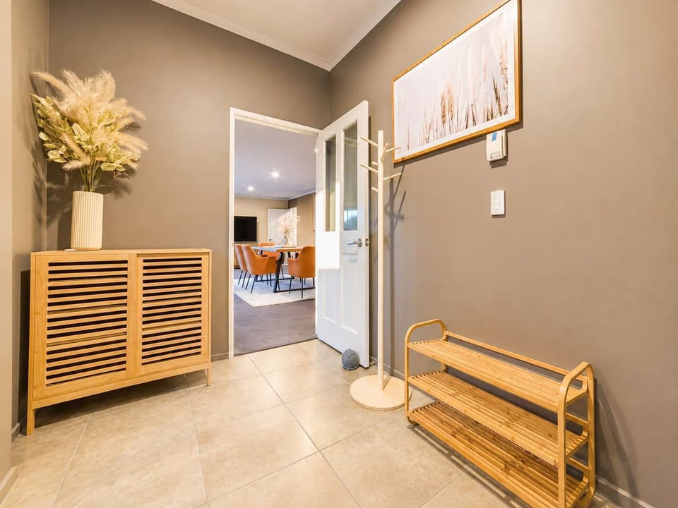 Welcoming entrance hallway with practical shoe storage, timber-look flooring and easy access to the home’s living areas.