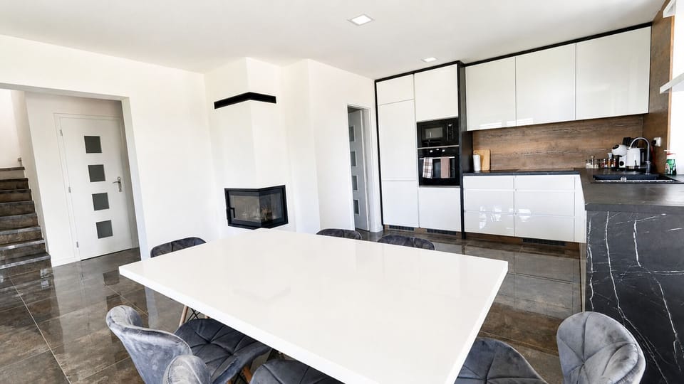 Bright modern kitchen and dining area with sleek finishes & cozy fireplace