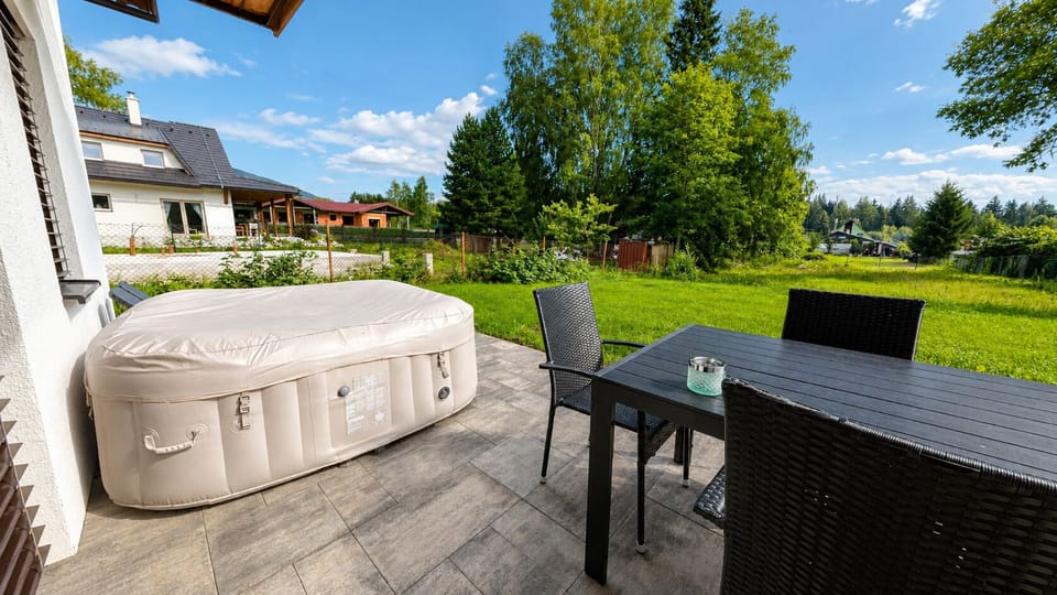 Private patio with hot tub, outdoor dining, and spacious green yard