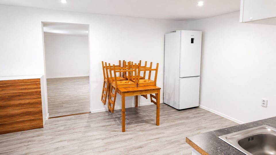Bright open dining area with full-size fridge and modern updated finishes