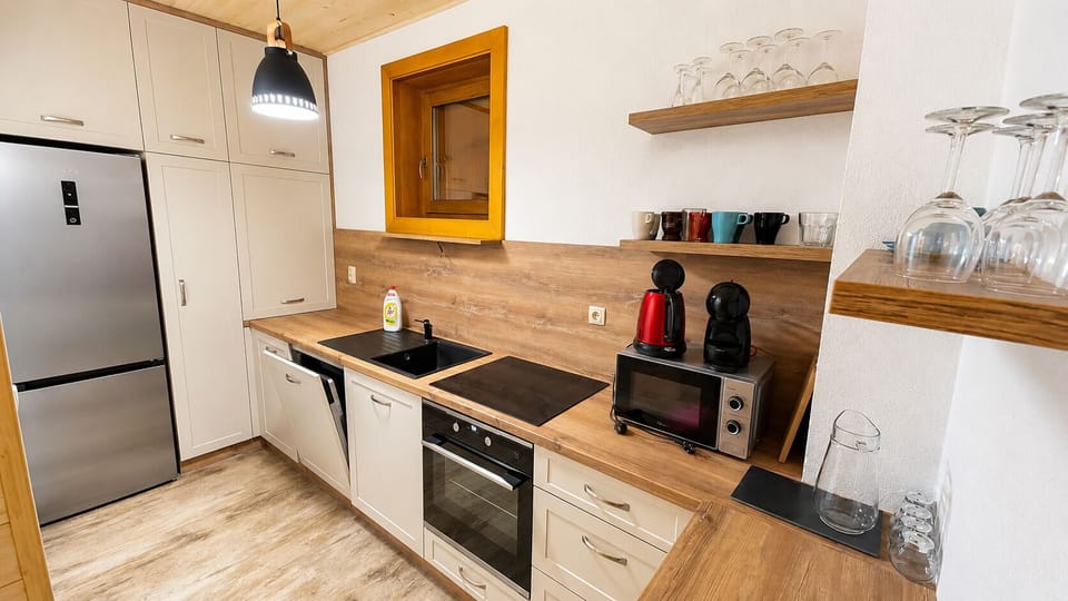 Modern, well-equipped kitchenette with coffee maker and warm wood finishes