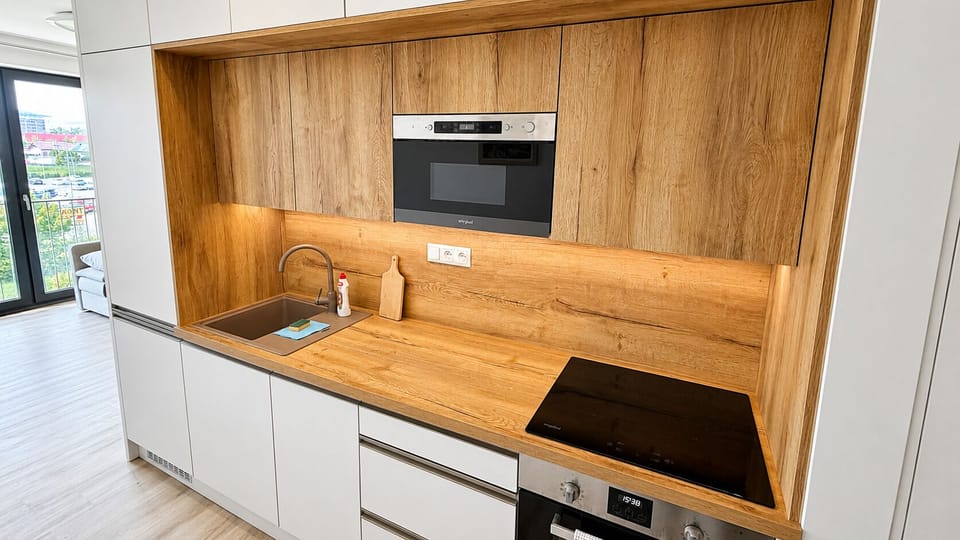Sleek modern kitchen with warm wood finishes and built-in appliances