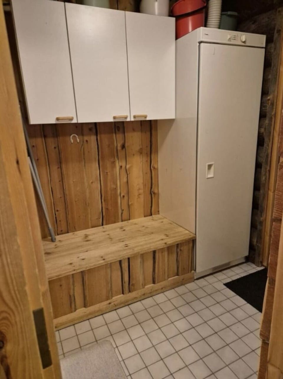 Entrance hallway with a wooden bench and overhead storage cupboards.