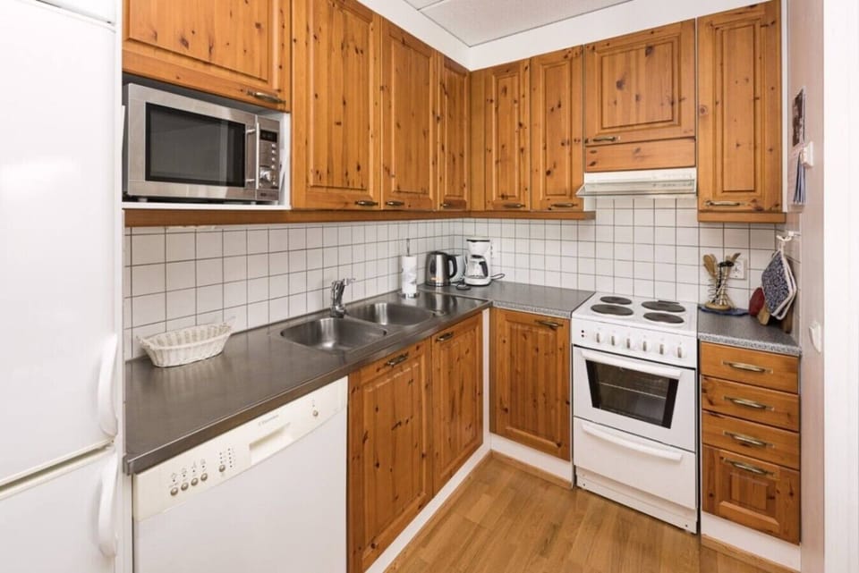 Fully equipped kitchen with an electric stove, oven, microwave and dishwasher.