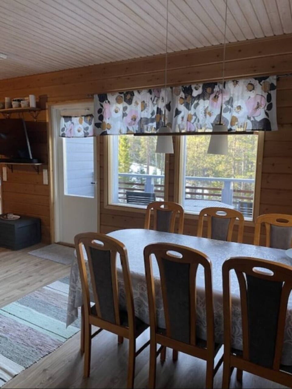 Dining area with a large wooden table and seating for six beside the window.