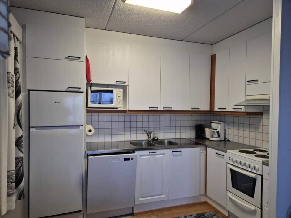 Kitchen equipped with a refrigerator, microwave, dishwasher and electric stove.