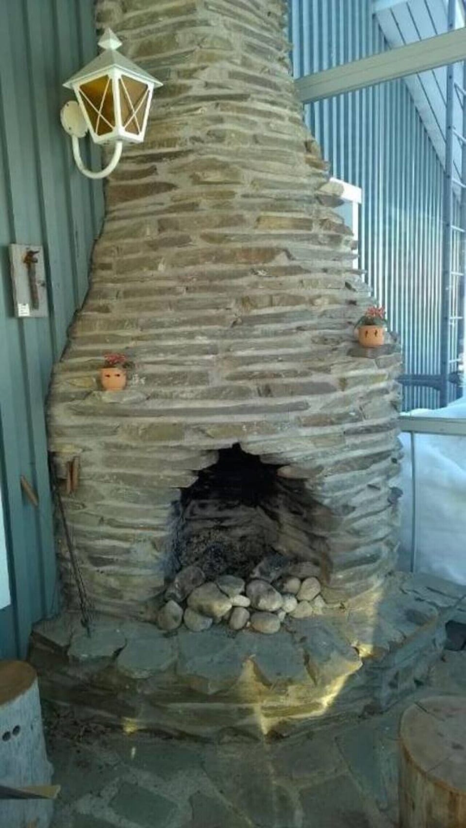 Stone fireplace built into the wall of the enclosed terrace.