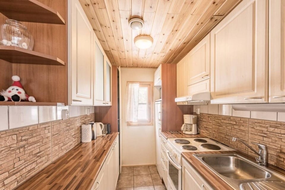 Fully equipped kitchen with modern appliances, wooden cabinetry, and everything needed to prepare meals.