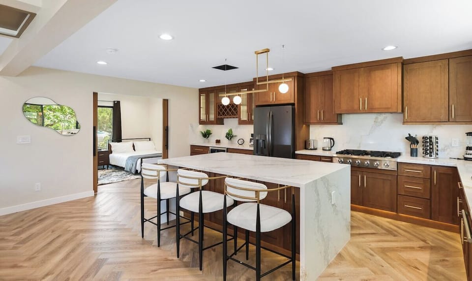 Modern kitchen showcasing refrigerator, gas range, and appliances. 