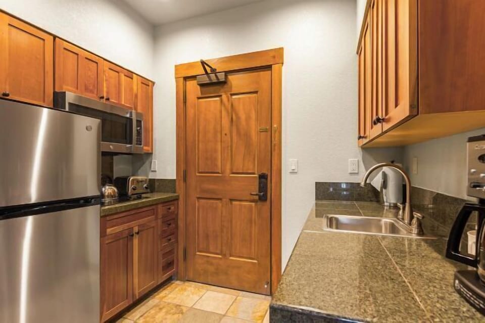 Cozy kitchenette with granite counters and stainless steel appliances