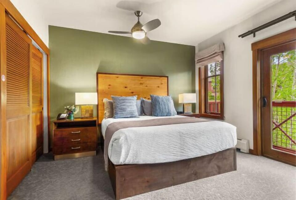 Cozy bedroom with wood accents, natural light, and balcony access
