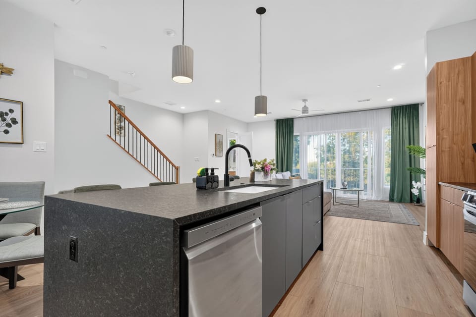 Bright open-concept kitchen with waterfall island and sunlit living space
