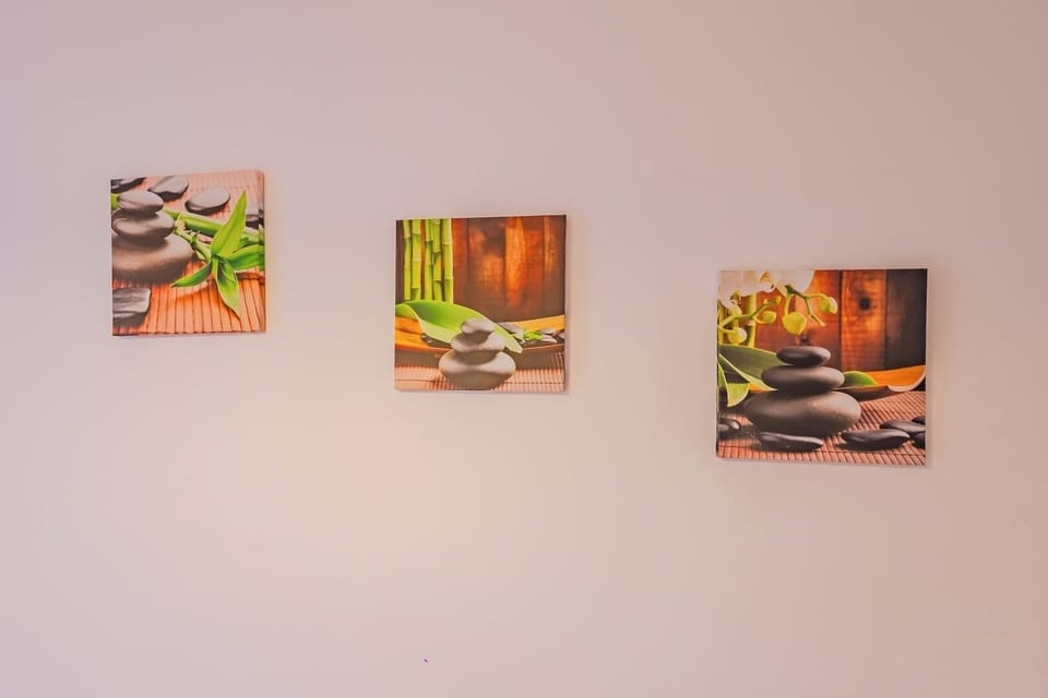 Decorative wall detail with zen-themed artwork — stones, bamboo and botanical prints. A calm, considered aesthetic throughout this centrally located Brasov studio in the historic Old Town area.