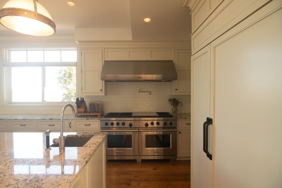 Bright chef’s kitchen with granite island and premium stainless range
