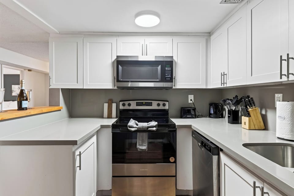 A streamlined kitchen keeps meal prep simple, with full-size appliances, generous cabinet storage, and the dining area just steps away.