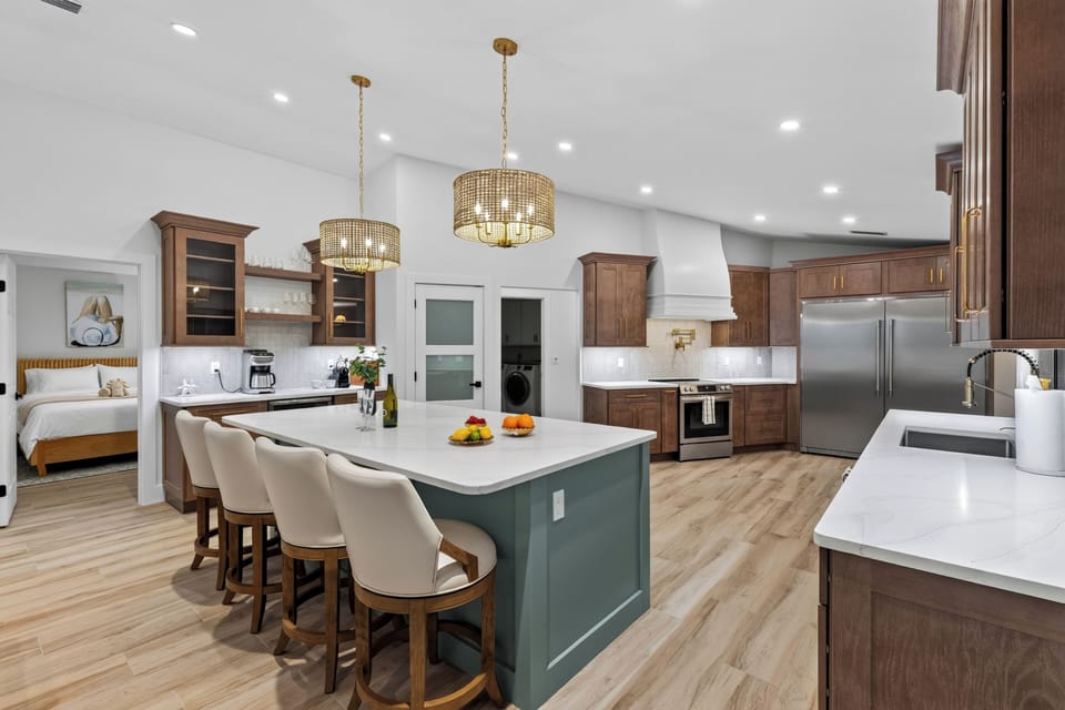 Open-concept kitchen and dining space with custom cabinetry and island seating.